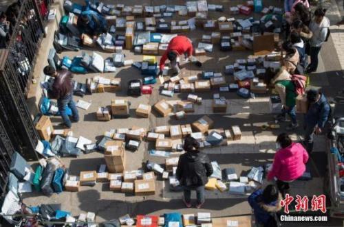 资料图:快递工作人员忙着分拣满地的快递。武俊杰 摄 点击进入下一页