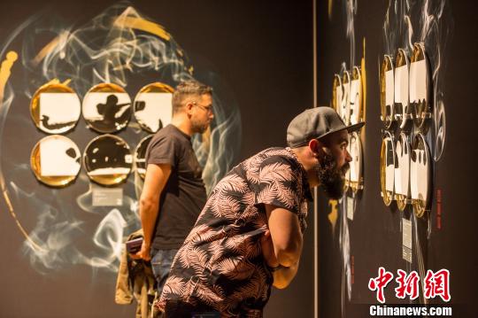 中国侨网图为当地观众在展览现场驻足观看。主办方供图