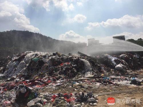 广州一大街塑料等垃圾堆成山 街道每天浇水防起火