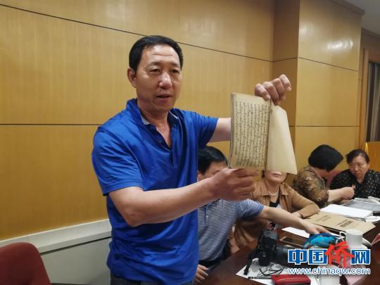 图为一战华工后裔马京东在展示爷爷的一份手稿。　孙婷婷 摄