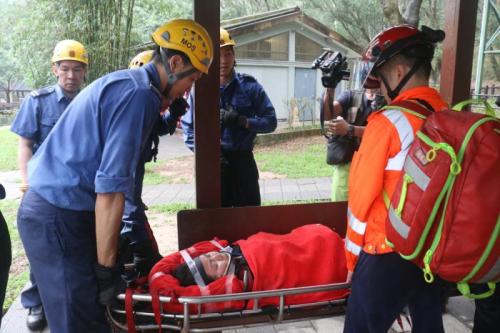 防员将堕崖受伤女事主抬下山送院 /大公报记者周庆邦摄