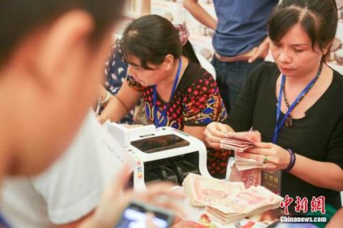 资料图：清点人民币。盘钰 摄 