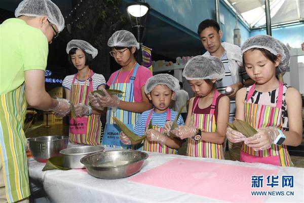 6月18日，小朋友在浙江省杭州市青少年发展中心“Do都城”举办的体验活动中包粽子。