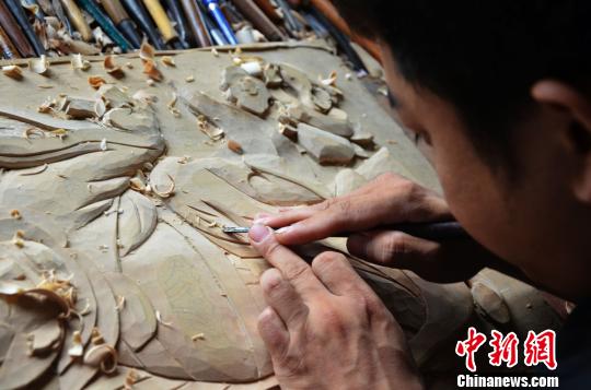 图为王吉波进行木雕工作。　郝学娟 摄