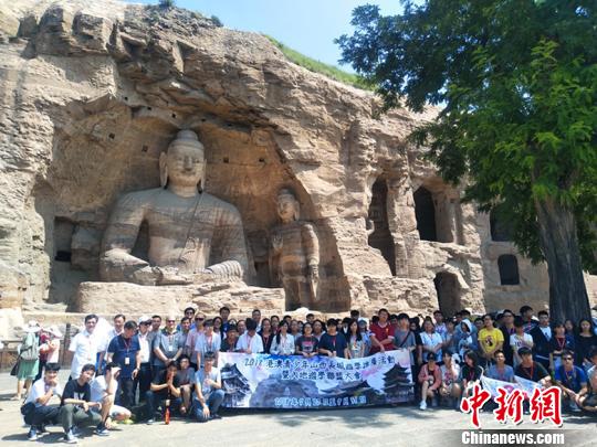 图为：港澳青少年在大同云冈石窟景区合影留念。刘小红 摄