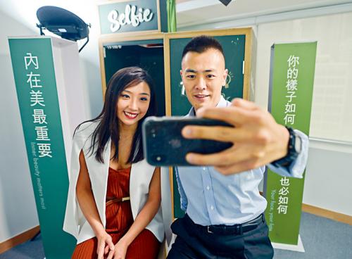 香港青年民间智库“MWYO”负责研究的调查员刘思颖(左),与智库总监刘鸣炜示范自拍。图片来源:香港《星岛日报》苏正谦/摄 香港青年民间智库“MWYO”负责研究的调查员刘思颖(左),与智库总监刘鸣炜示范自拍。图片来源:香港《星岛日报》苏正谦/摄