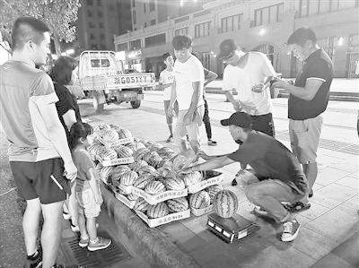李恩慧(右一)每天晚上7点准时出摊卖西瓜 点击进入下一页