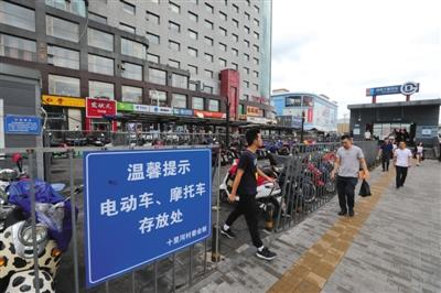 8月8日，朝阳区十里河地铁站，地铁站出入口处设立了电动车和摩托车存放处。 新京报记者 王飞 摄