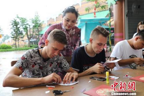 中国侨网饶宝莲正在指导“洋徒弟”剪纸　李星凯　摄