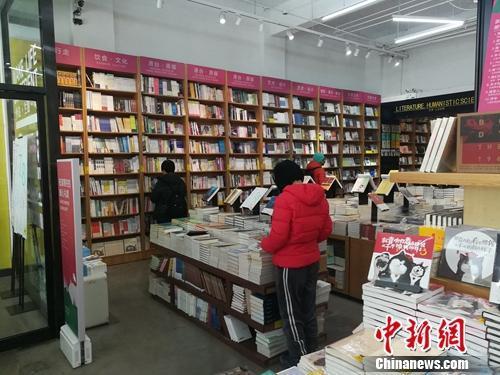 资料图:北京言几又书店(中关村店)内,读者正在翻看摆放的书籍。上官云 摄 点击进入下一页