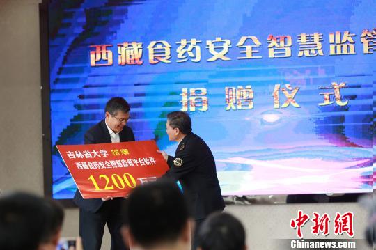 8月23日，在捐赠仪式上，吉林大学党委常委、副校长郑伟涛(左)向西藏自治区食品药品监管局党组书记、副局长王东升转交估值约1200万元人民币的监管平台软件。西藏自治区食品药品监管局 供图