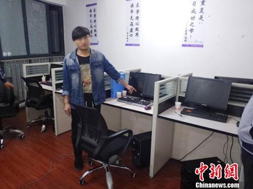 图为警方抓获的犯罪嫌疑人指认涉案电脑。 观山湖警方供图 张伟 摄