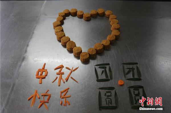 大熊猫专属月饼及大熊猫喜爱的食物拼出的节日祝贺图案。