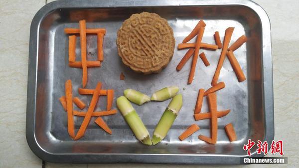 大熊猫专属月饼及大熊猫喜爱的食物拼出的节日祝贺图案。2