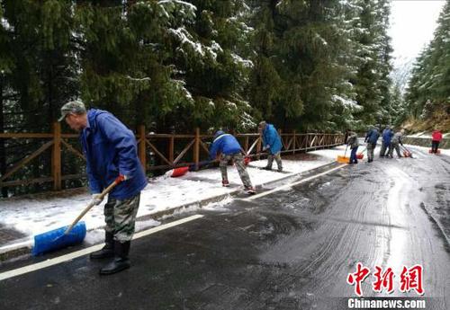 景区工作人员清理道路积雪。　王小军 摄
