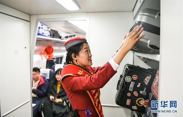 9月30日，在哈尔滨西站，乘务人员在即将发车的哈佳铁路列车上摆放大件行李。