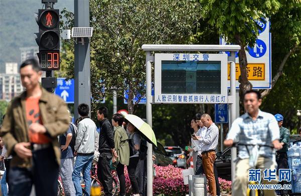 行人通过深圳新洲路和莲花路交叉路口（4月10日摄）。