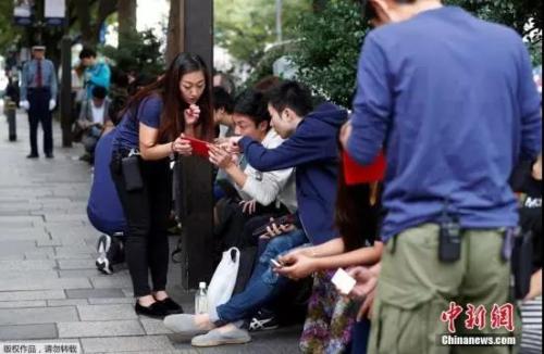 资料图：2017年，新款iPhone开售，果粉排长队购买。