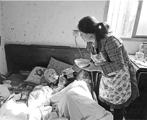 蒋增美一勺一勺喂老人进食。　盛伟 摄