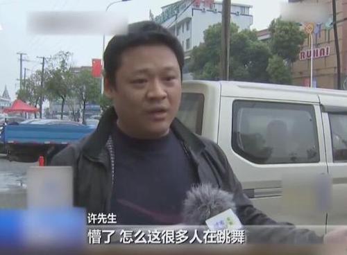 大妈在停车场跳广场舞 用铲车铲走轿车还贴告示牌