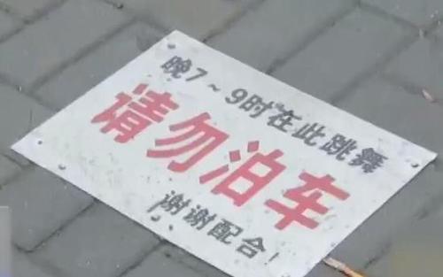 大妈在停车场跳广场舞 用铲车铲走轿车还贴告示牌