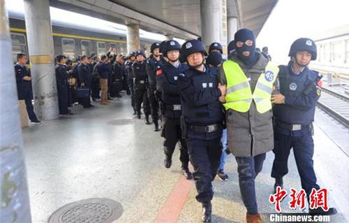 图为警方押解犯罪嫌疑人回到兰州。　樊奕昕 摄