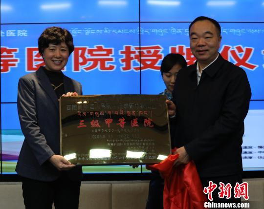 图为西藏自治区卫健委党组书记王云亭向西藏成办医院党委书记李晓萍授予“三级甲等医院”名牌。西藏自治区党委宣传部供图