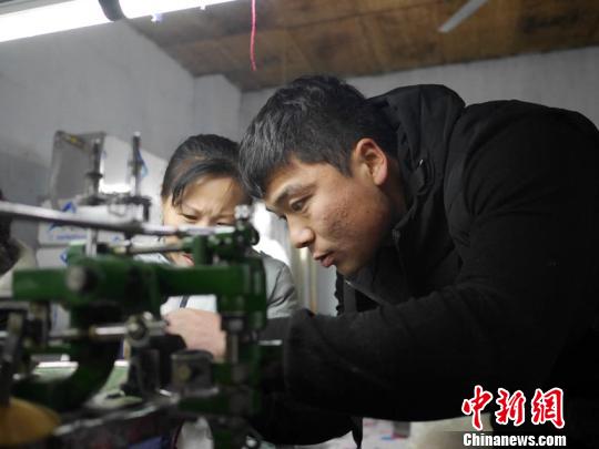 车间的技术指导正在教授刚刚进厂的女工最基本的操作 苍雁 摄