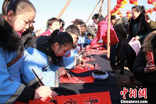 书法班学生身着汉服写春联。　赵桂华 摄