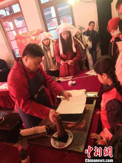 武强年画省级非遗传承人康英勤现场演示武强木版年画印制技艺。　陈贺芝 摄
