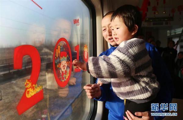 2月4日，乘客在江苏泰州开往黑龙江哈尔滨的Z157次列车上观看窗花。