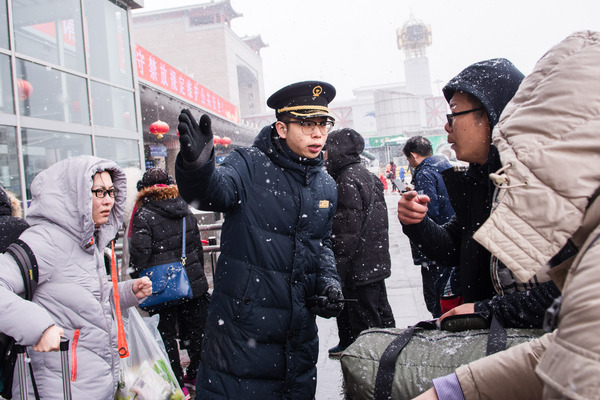 北京西站工作人员在站前广场引导旅客。（摄影：马韵楠）