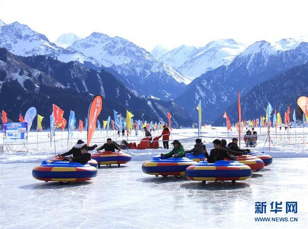 游客在天山天池景区体验冰上娱乐项目（2月6日摄）。