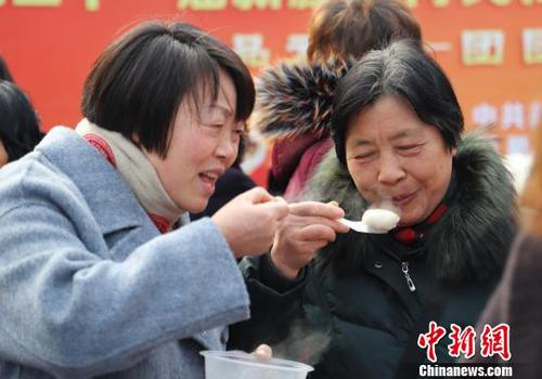 图为民众品尝刚出锅的汤圆。　胡小丽 摄
