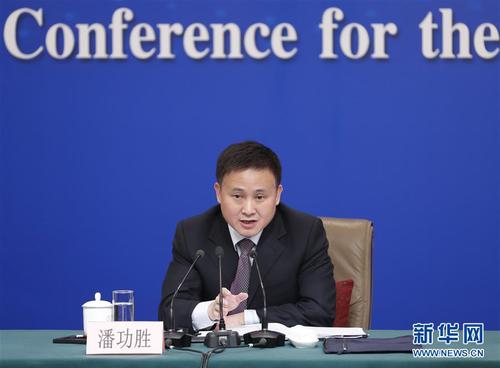 潘功胜在回答记者提问。 新华社记者 沈伯韩 摄
