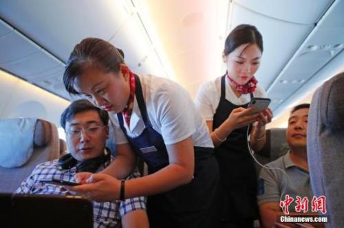 资料图：乘务员们在客舱内为旅客调试机上上网功能。<a target='_blank' href='http://www.chinanews.com/'>中新社</a>记者 殷立勤 摄
