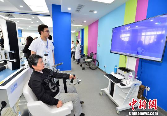 图为在人工智能康复机器人训练中心，几名残疾人正在治疗师的指导下进行训练。　张一辰 摄