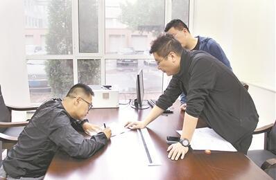 图为李昊(左一)在谈话笔录上签字。 尹兆书 摄 点击进入下一页