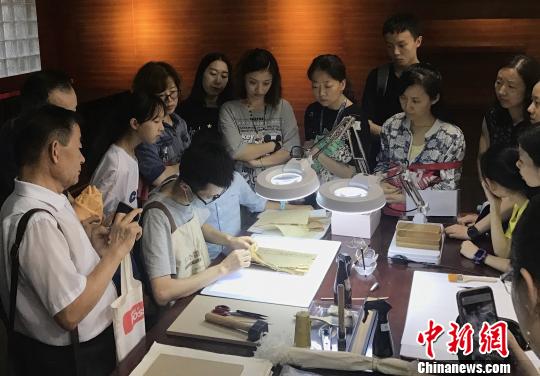 图为专业人员现场演示对古书的修复过程。　张一辰 摄