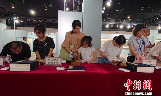 图为民众翻阅古籍。　张一辰 摄