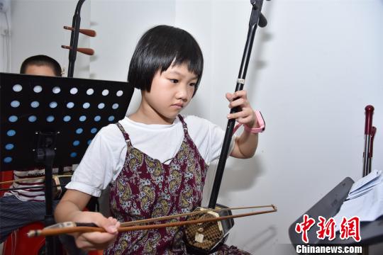 7岁的张泷月正认真练习二胡。　陈龙山 摄