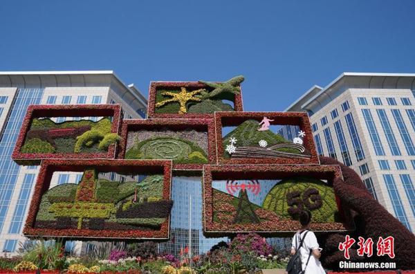9月24日，市民观赏北京东方广场旁的“繁荣发展”主题花坛。随着国庆节临近，北京街头主题花坛陆续亮相。中新社记者 张兴龙 摄