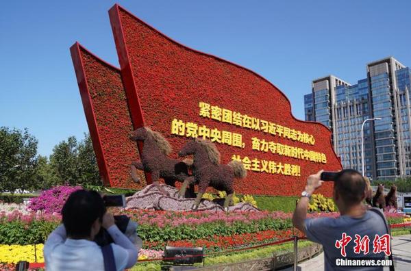 9月24日，市民在位于北京东单西北角的“奋进新时代”主题花坛前拍照。随着国庆节临近，北京街头主题花坛陆续亮相。中新社记者 张兴龙 摄