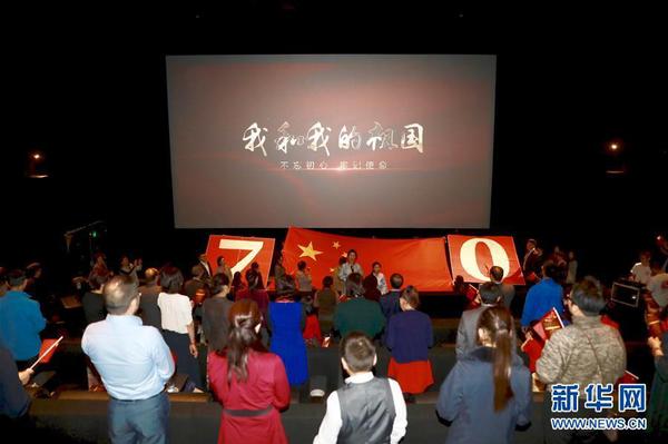 9月30日晚，在澳大利亚首都堪培拉，观众在电影《我和我的祖国》当地首映礼上合唱同名主题歌。新华社发(储晨 摄)