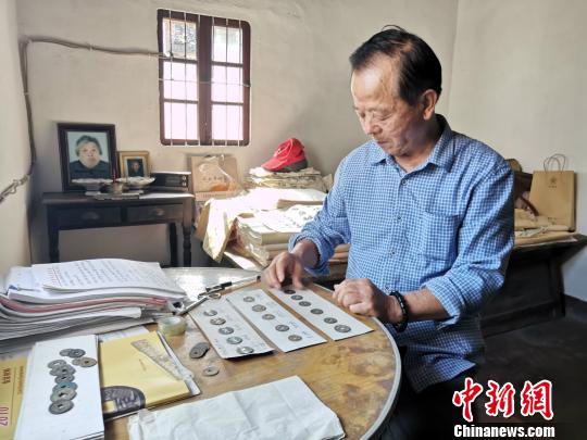 章明夫在整理古钱币　施紫楠　摄