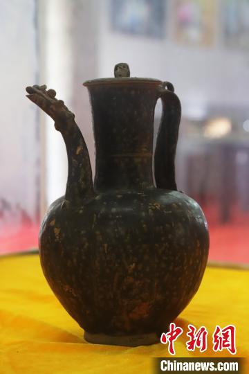 图为江西省赣州市大余县博物馆展出此次北宋古窑址出土的黒釉龙首流长颈瓜棱执壶。捏塑的龙首流，栩栩如生，很有特色。　吴寿生 摄