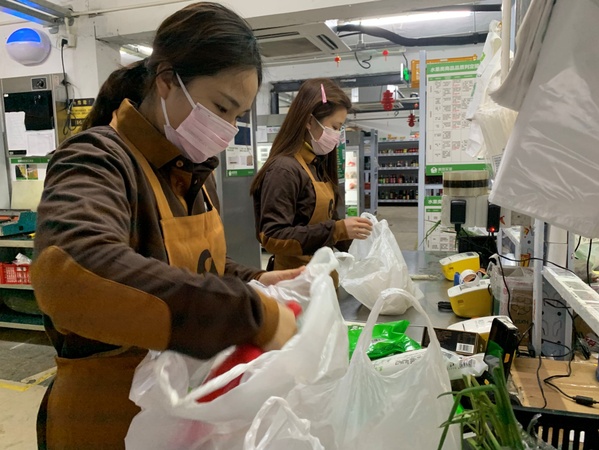 图为美团买菜员工为用户分装订单菜品。