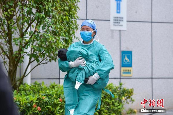 2月11日，海南省第一例新冠肺炎确诊儿童从海口市人民医院治愈出院。这也是截至目前，海南省最小的确诊病例治愈出院。入院时该患儿仅3个多月大，孩子的父母均为确诊病例。图为护士将治愈出院的女婴抱出隔离区。中新社记者 骆云飞 摄