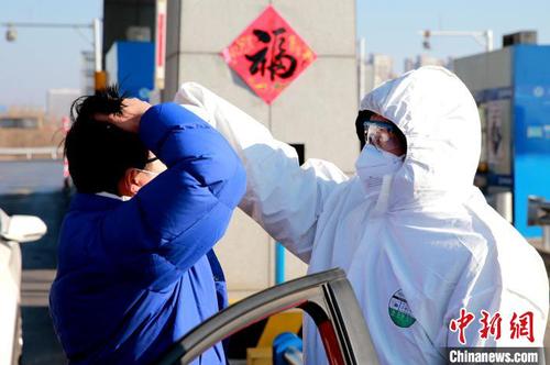 资料图：图为防疫人员正在为过往车辆司机测量体温。　梁犇 摄
