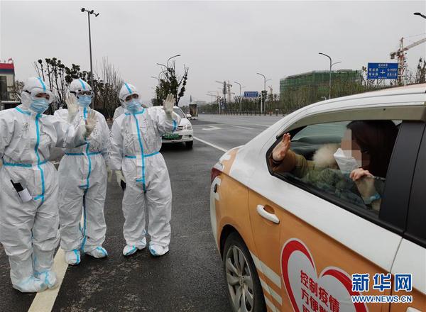 　1 武汉雷神山医院32名新冠肺炎患者2月27日治愈出院，这是一名新冠肺炎治愈患者出院后与医护人员告别（手机拍摄）。 新华社发（高翔 摄）